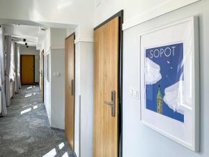 a hallway with a door and a picture on the wall at SeaSide Sopot - butikowe noclegi przy plaży in Sopot