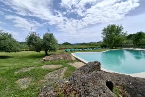 a swimming pool with blue chairs in a yard at Villa Montepulciano by Mmega in Canonica +37 photos