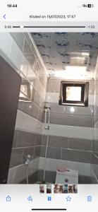 a bathroom with a window and a tiled wall at Beach Town flat1 in Mazer +13 photos