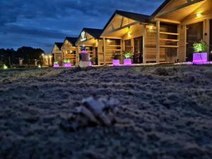 a house on the beach at night at Domki DIAMENT, Comfortable Cottages near the Sea & Lake in Dziwnówek in Dziwnówek