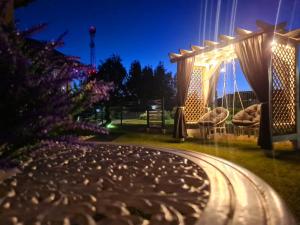 a garden with a pergola at night at Domki DIAMENT, Comfortable Cottages near the Sea & Lake in Dziwnówek in Dziwnówek