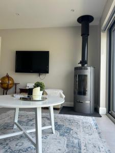 a living room with a table and a fireplace at Mary’s Seaview Clifden in Galway