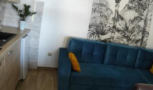 - un canapé bleu avec un oreiller jaune dans le salon dans l'établissement Bursztynowe Zacisze Domek 2 Chłopy ul Turystyczna 6, à Chłopy 6 autres photos