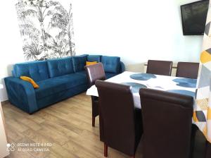 un salon avec un canapé bleu et une table dans l'établissement Bursztynowe Zacisze Domek 2 Chłopy ul Turystyczna 6, à Chłopy