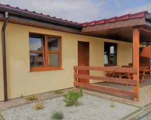 une petite maison avec un banc et un patio dans l'établissement Bursztynowe Zacisze Domek 2 Chłopy ul Turystyczna 6, à Chłopy