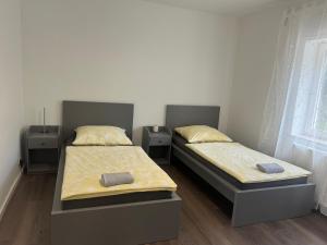 DierdorfにあるNeue Ferienwohnung Dierdorfのツインベッド2台&テーブル2台付