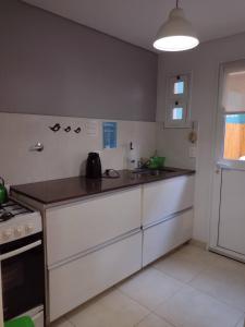 a kitchen with white cabinets and a counter top at Casa de Mar in Puerto Pirámides