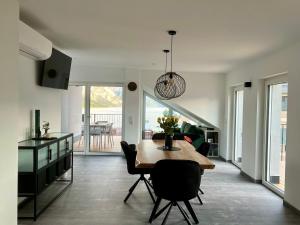 a kitchen and dining room with a table and chairs at Wolfis Traunseeblick - mit Klimaanlage u kostenlosem Parkplatz direkt an der Unterkunft in Gmunden