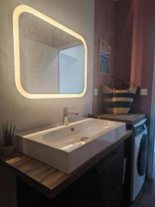 a bathroom with a large sink with a large mirror at AMARRÉ Gîte Bambou T2 Chambre indépendante in Sarzeau