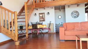 a living room with a staircase and a table and a couch at Plage Miramar in La Londe-les-Maures