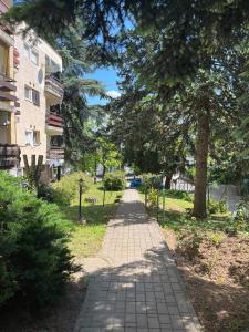 a brick path in a park next to a building at Rózsakő Apartman in Balatonalmádi