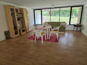 a living room with a table and chairs and a couch at Rózsakő Apartman in Balatonalmádi