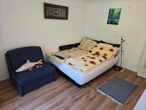a bedroom with a bed and a chair in it at Rózsakő Apartman in Balatonalmádi