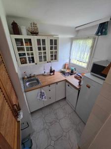 a small kitchen with a sink and a refrigerator at Rózsakő Apartman in Balatonalmádi