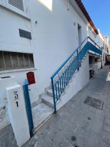 a white building with a blue railing next to a staircase at Al Capitello in Lacco Ameno