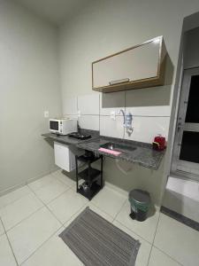 a kitchen with a counter with a sink and a microwave at Apt na Lapa - RJ in Rio de Janeiro
