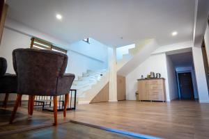 a living room with a chair and stairs at White House in Târgu Jiu