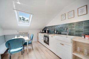 Una cocina con una mesa y sillas y un fregadero. en Cozy Apartment, en Prien am Chiemsee
