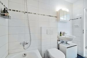 Un baño blanco con inodoro y lavabo. en Cozy Apartment, en Prien am Chiemsee