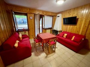 a living room with two red couches and a table at Berto’s House in Montoso