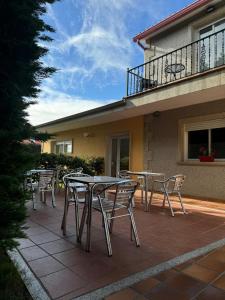 patio ze stołami i krzesłami przed budynkiem w obiekcie Casa Balea w mieście Balea