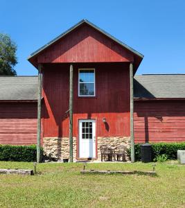 un granero rojo con una mesa delante en Hawks Nest Loft, en Crawfordville