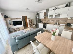 a living room with a blue couch and a table at Deák Apartman Gárdony in Gárdony