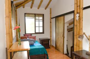 a bedroom with a bed and a table and a window at Charming Coffee Region Farm Escape in Armenia +29 photos