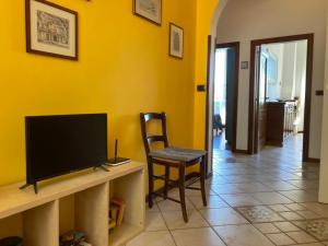 a living room with a tv and a chair at Appartamento Forte Malatesta in Ascoli Piceno