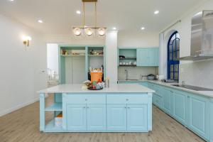 eine Küche mit blauen Schränken und einer weißen Arbeitsplatte in der Unterkunft Villa Hồ Tuyền Lâm Đà Lạt View Rừng Thông Đà Lạt in Xuan An