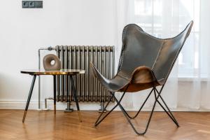 a black chair next to a table and a radiator at 2BR 95m2 apartment in Old Town with Free Parking and Sauna! in Tallinn