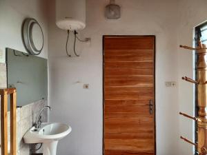 bagno con lavandino e porta in legno di Villa Jardin d' Eden a Lomé Altre 16 foto