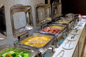 a row of trays of food on a buffet line at Skylark Boutique and Spa in Hanoi