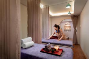 a woman sitting on a bed in a hotel room at Skylark Boutique and Spa in Hanoi