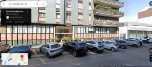 ein Parkplatz mit vor einem Gebäude geparkten Autos in der Unterkunft Kibilù - Via Morosini - Policlinico - Centro Città in Mailand