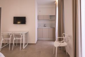 a kitchen with a table and chairs and a television at Atena Room in Letojanni