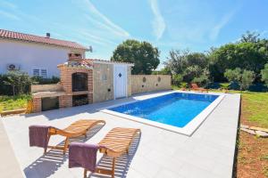 basen na podwórku z krzesłami i domem w obiekcie Vacation house Ulika w mieście Gabonjin