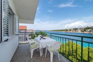 a balcony with a table and chairs and the water at Apartments Ivica in Primošten