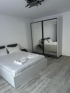 a bedroom with a bed and a large mirror at Apartament Emma in Mangalia