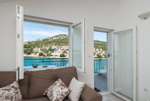 a living room with a couch and a view of the water at Apartments Ivica in Primošten