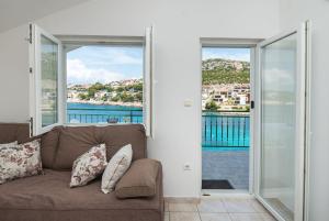 a living room with a couch and sliding glass doors at Apartments Ivica in Primošten