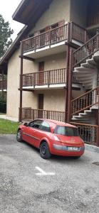 a red car parked in front of a building at Studio Résidence Val d'Escreins in Guillestre