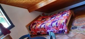 a bedroom with a bed with a colorful comforter at Studio Résidence Val d'Escreins in Guillestre
