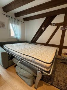 a bed sitting on top of a bed in a room at Colombages de la Lauch in Colmar