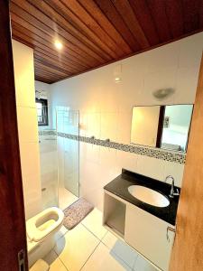 Un baño con inodoro, lavabo y ducha. en Novo Duplex em condomínio com piscina Juquehy, en São Sebastião