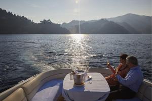 two people sitting at a table on a boat on the water at Splendido, A Belmond Hotel, Portofino in Portofino
