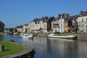 two boats are docked in a river in a city at Spacieux T3 lumineux dans quartier historique avec wifi in Redon