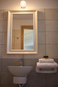 a bathroom with a sink and a mirror and towels at Tiepolo Skyros in Skiros +18 photos