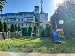 plac zabaw ze zjeżdżalnią w podwórzu z budynkiem w obiekcie Amko Style Apartamenty Nord 8 z ogródkiem Willa Nord w Jastrzębiej Górze