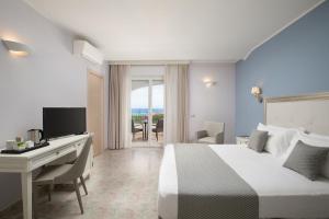 a hotel room with a bed and a desk with a computer at Hotel Rosa dei Venti in Castelsardo